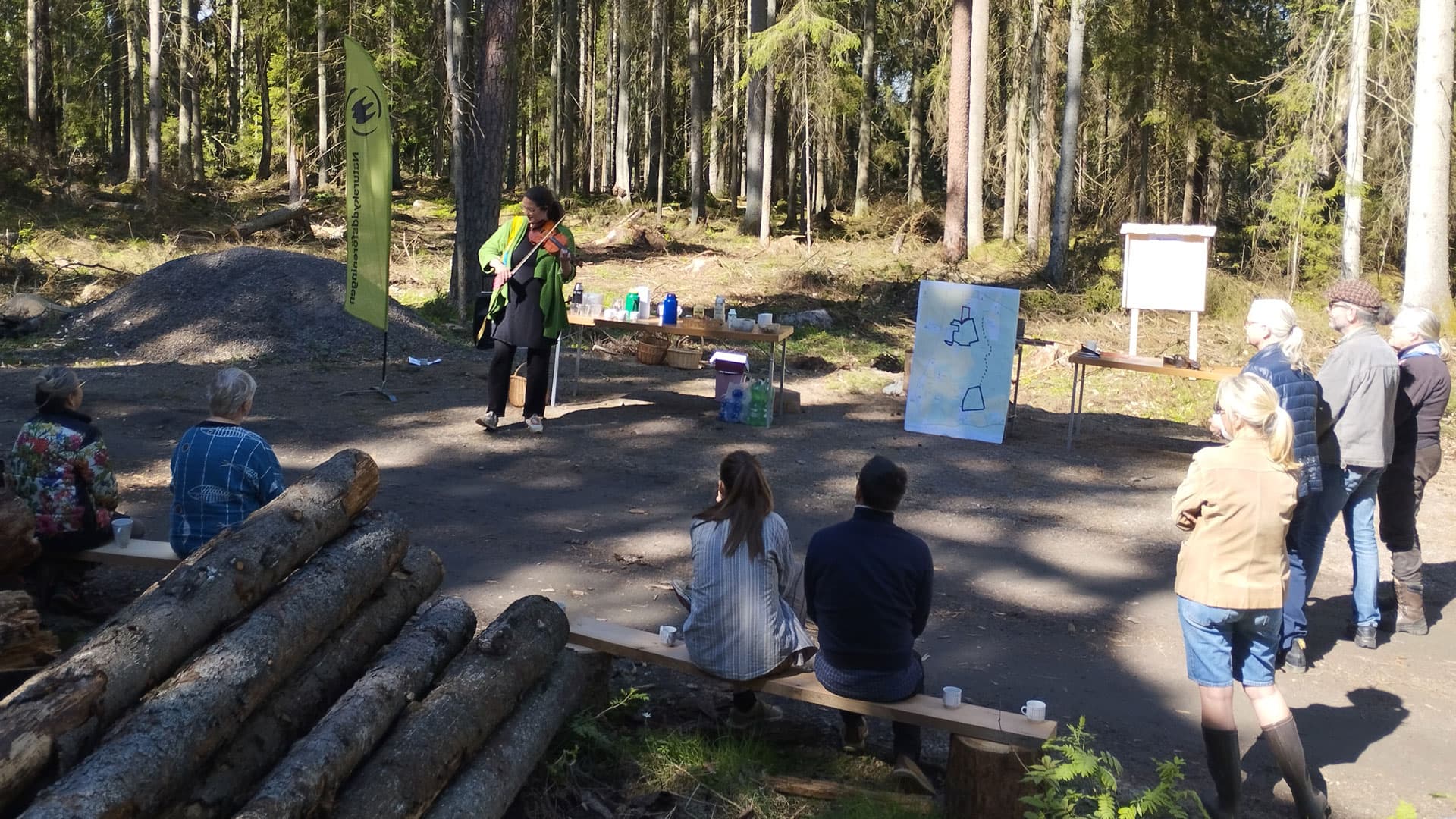 Fiolspel på ena sidan av skogsvägen och publiken på andra sidan