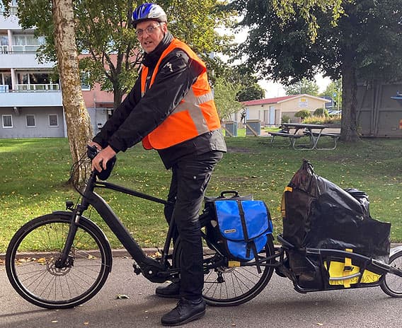 En vuxen hjälper ett barn att transportera leksaker med cykelkärra