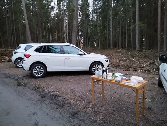 Bilar och ett välfyllt bord på skogens bilparkering