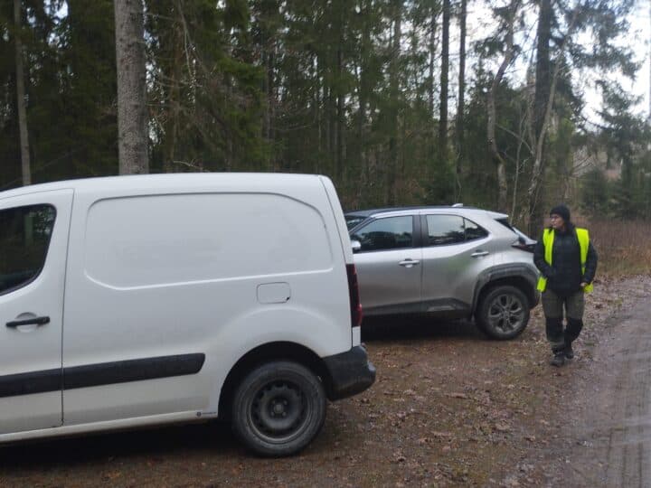 Bilar står på parkeringen och ledaren kommer gående